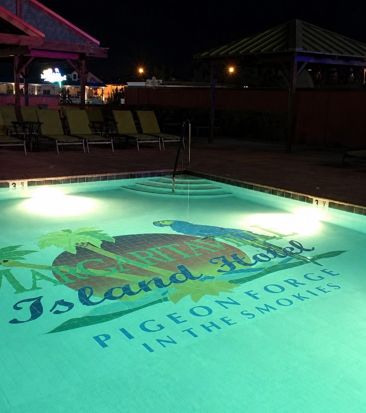Custom pool tile mural lit at night